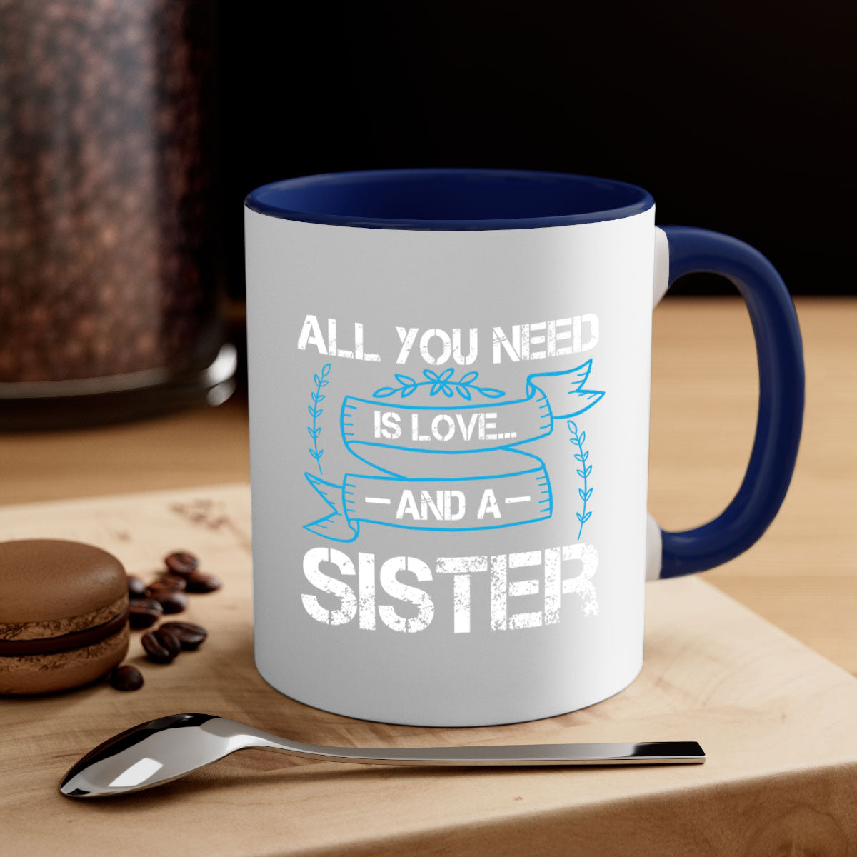 Ceramic mug with 'All You Need Is Love… and a Sister' design, featuring a two-tone color scheme and glossy finish.