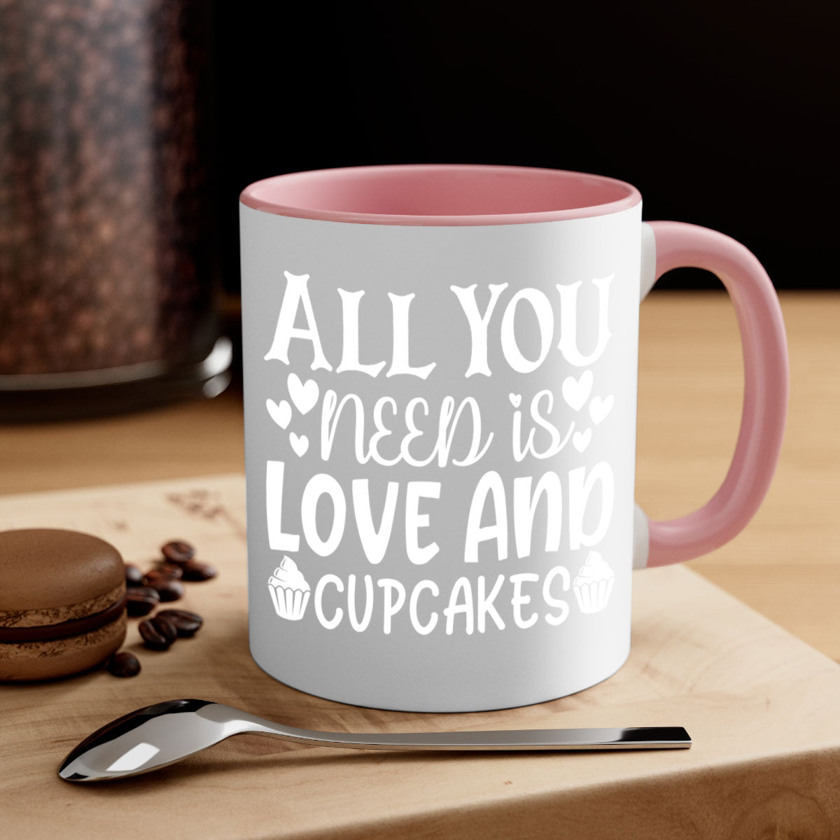 A two-tone ceramic mug with the phrase 'All You Need Is Love and Cupcakes' printed on it, featuring a colored handle and glossy finish.