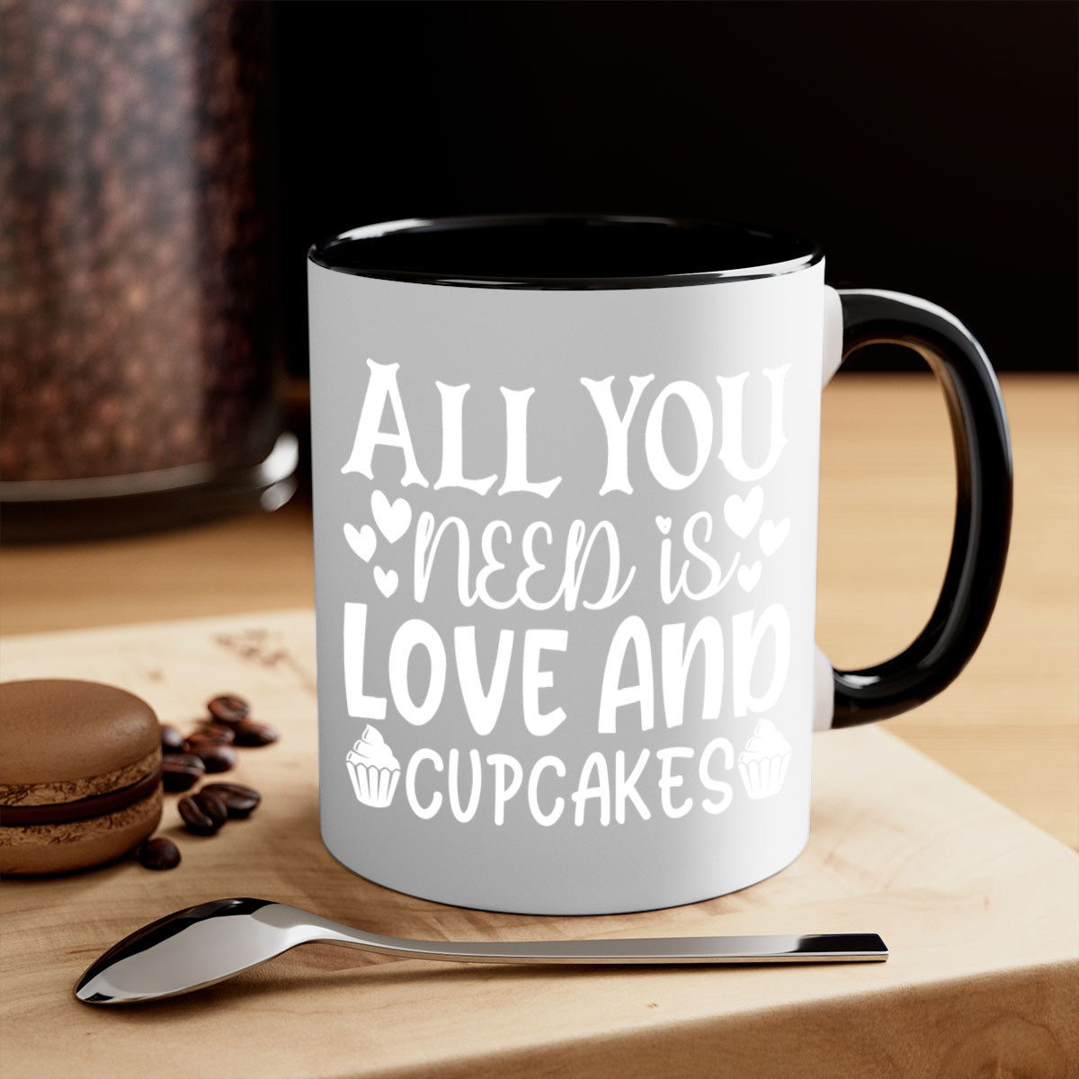 A two-tone ceramic mug with the phrase 'All You Need Is Love and Cupcakes' printed on it, featuring a colored handle and glossy finish.