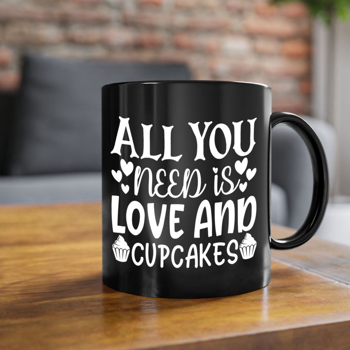 A two-tone ceramic mug with the phrase 'All You Need Is Love and Cupcakes' printed on it, featuring a colored handle and glossy finish.
