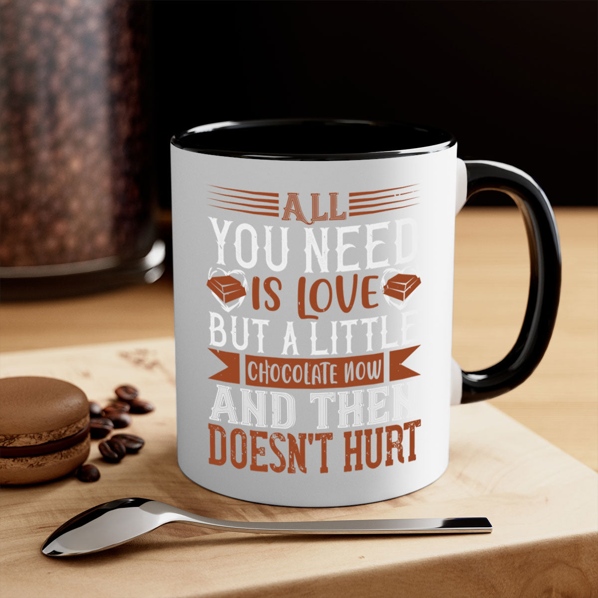 A two-tone ceramic mug with a colored handle and interior, featuring the phrase 'All You Need is Love but a Little Chocolate Now and Then Doesn't Hurt' in a stylish font.