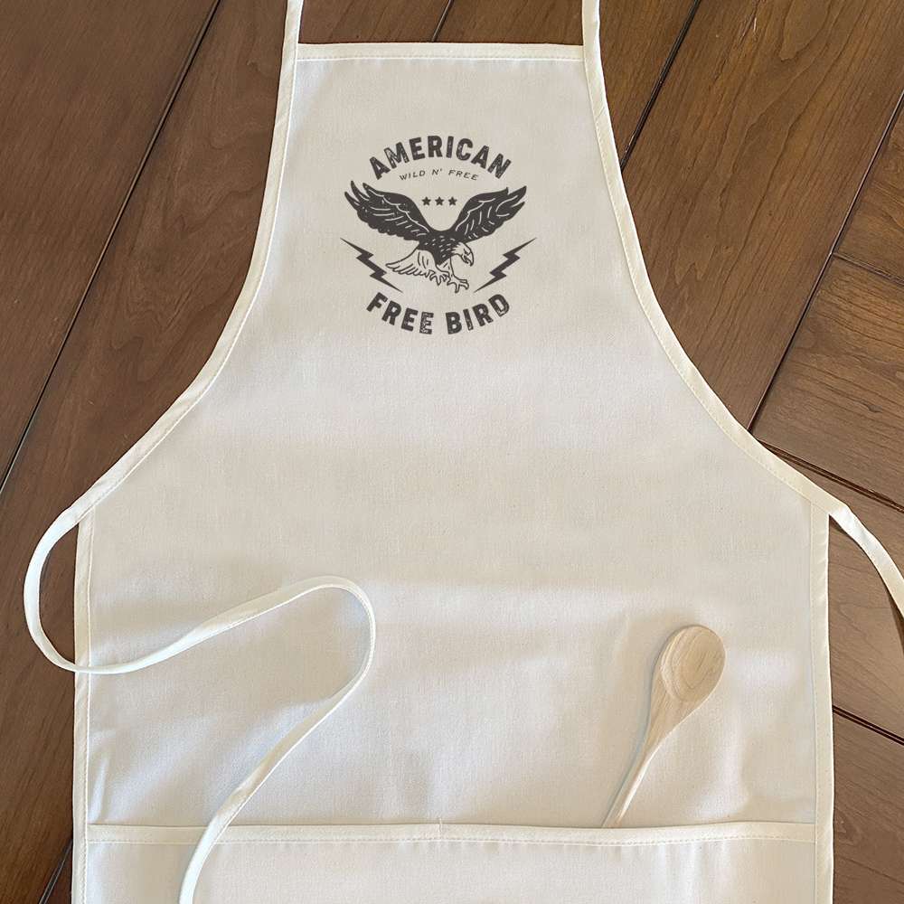 American Free Bird Women's Apron in cotton canvas with natural twill ties and divided front pocket, featuring a stylish design.