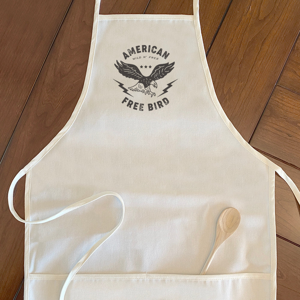 American Free Bird Women's Apron in cotton canvas with natural twill ties and divided front pocket, featuring a stylish design.