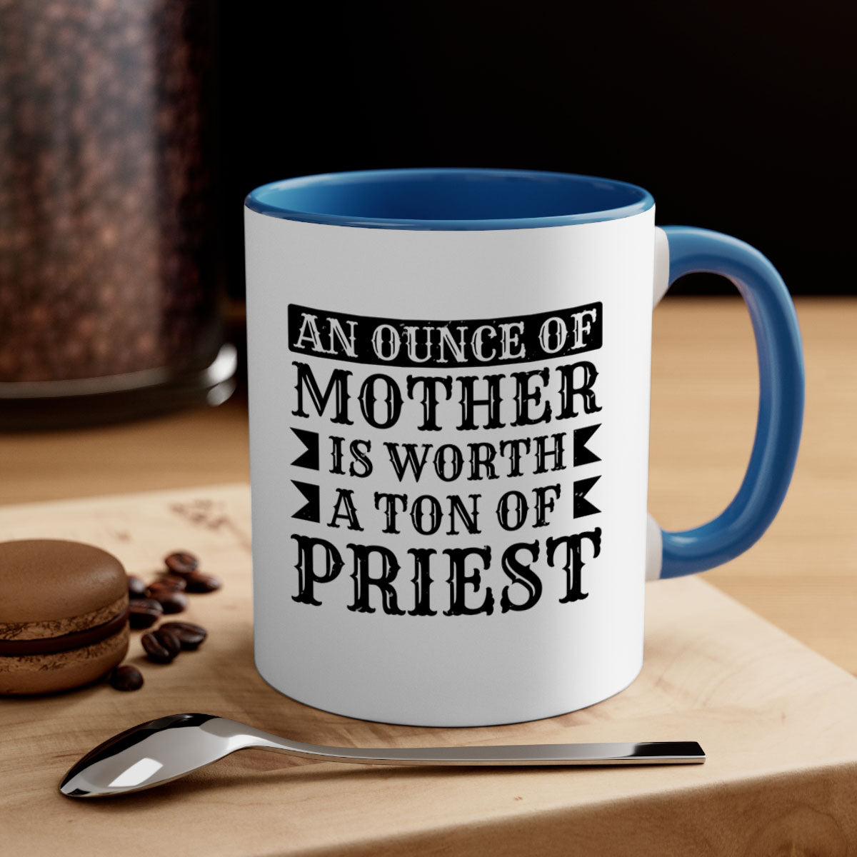 Two-tone ceramic mug with colored handle and interior, featuring the phrase 'An Ounce of Mother is Worth a Ton of Priest'.