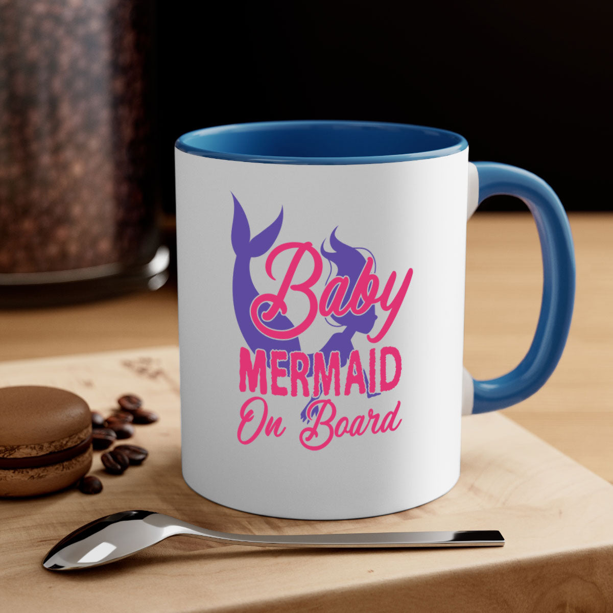 A colorful Baby Mermaid On Board mug with a glossy finish, featuring a mermaid design and a C-shaped handle, available in multiple colors.