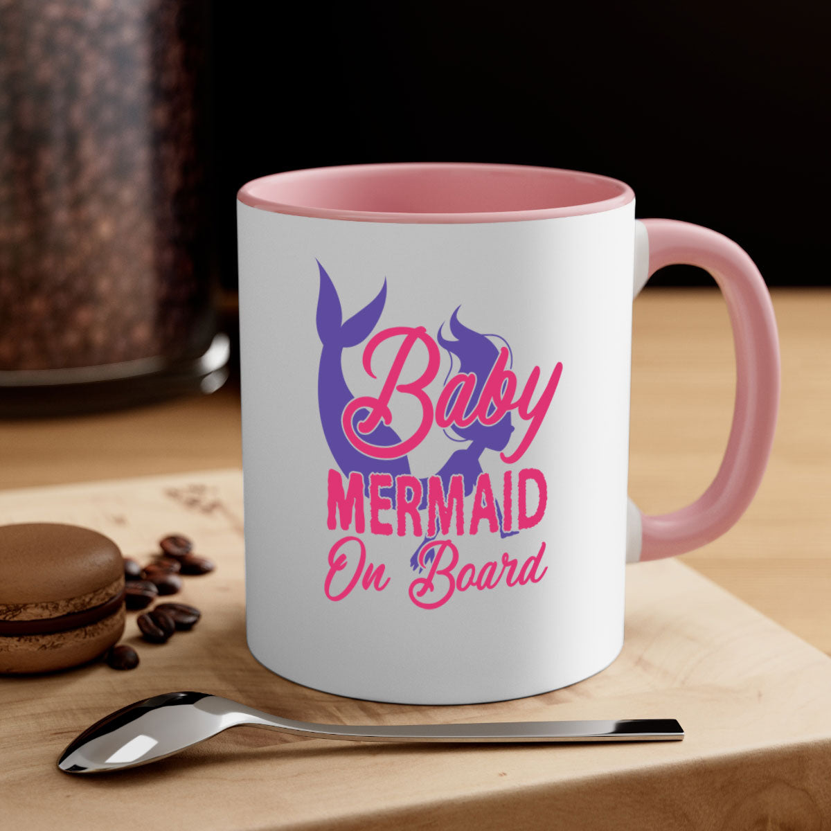 A colorful Baby Mermaid On Board mug with a glossy finish, featuring a mermaid design and a C-shaped handle, available in multiple colors.