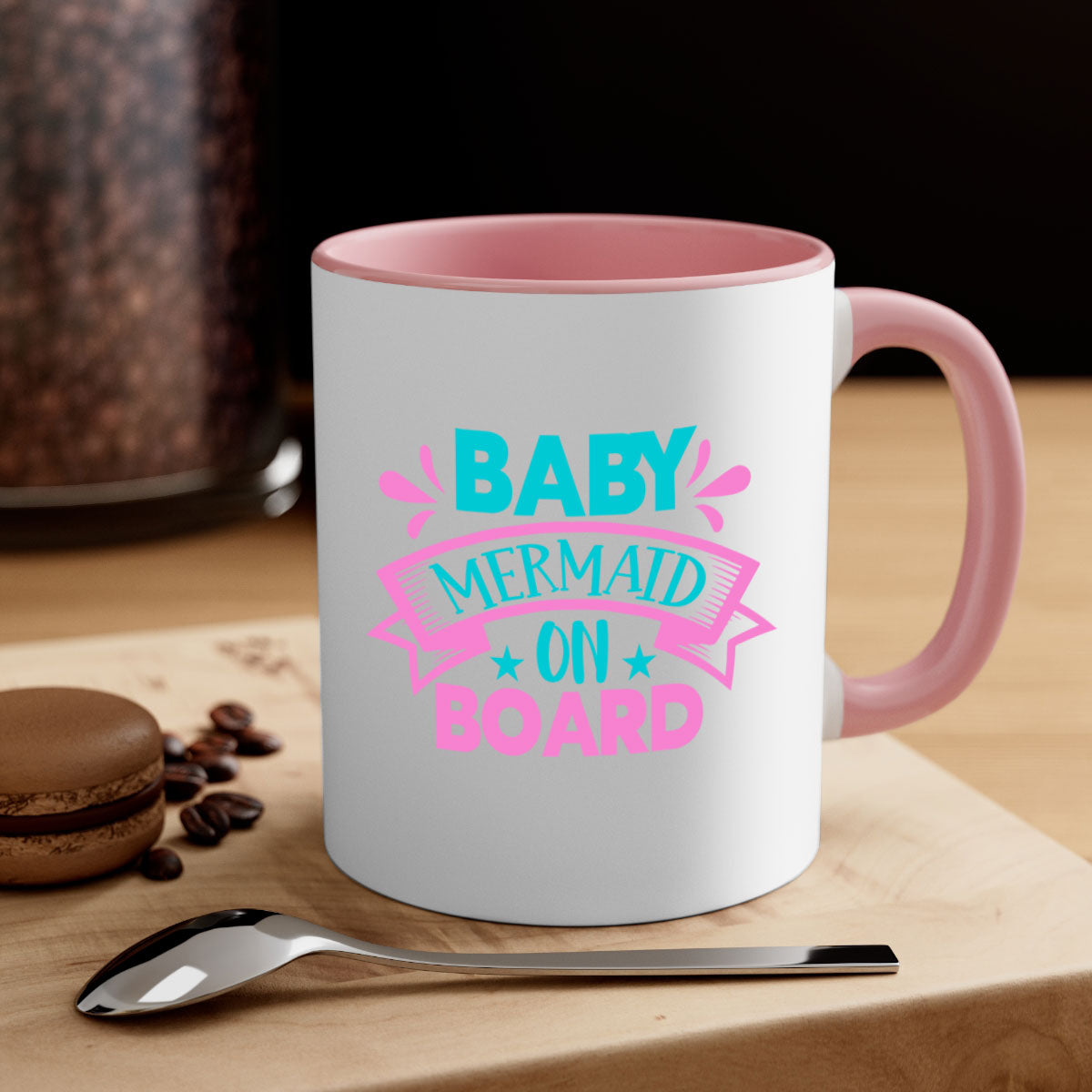 A colorful Baby Mermaid On Board mug with a glossy finish, featuring a mermaid design and a C-shaped handle, available in multiple colors.