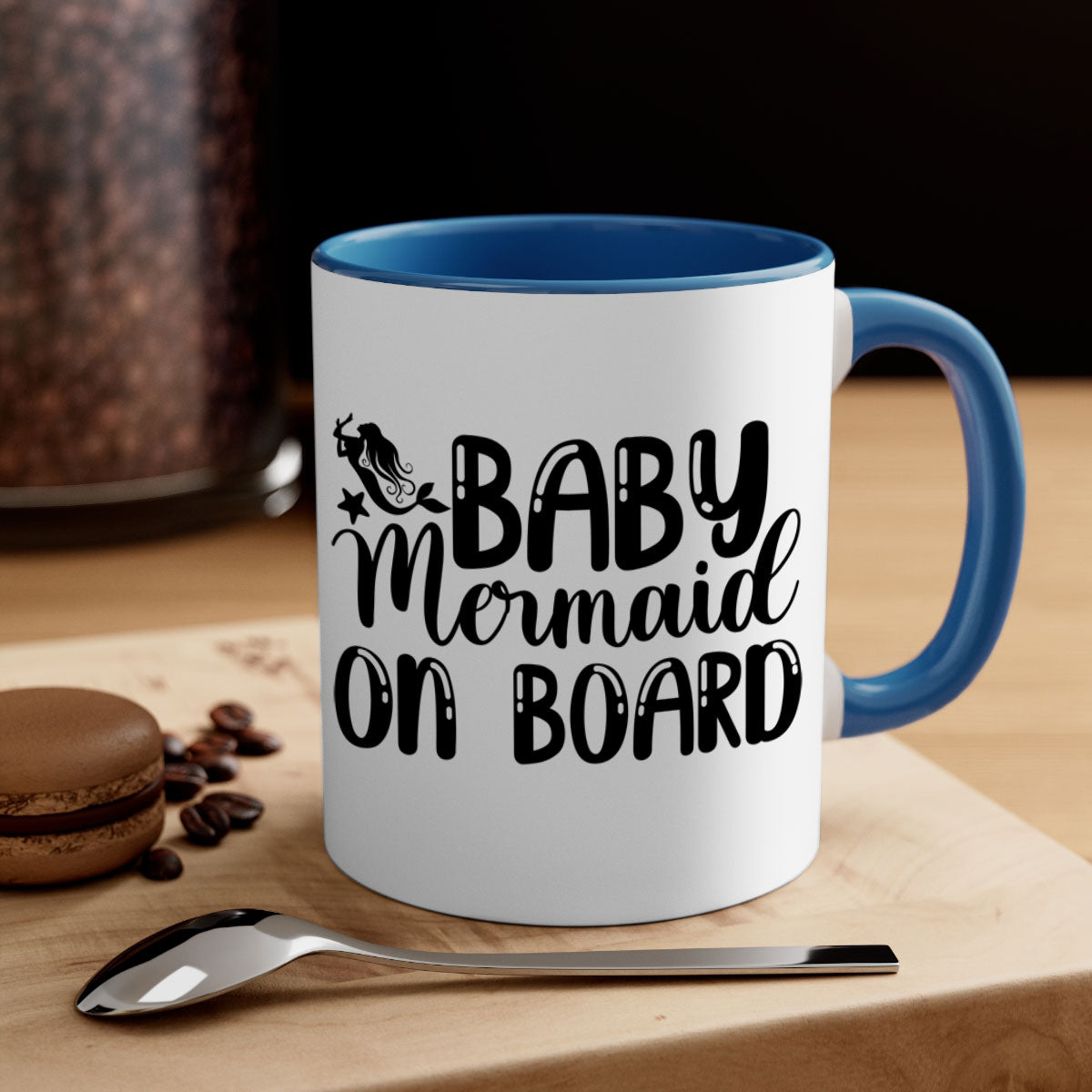 A colorful Baby Mermaid on Board mug with a glossy finish, featuring a mermaid design and a C-shaped handle, available in multiple colors.