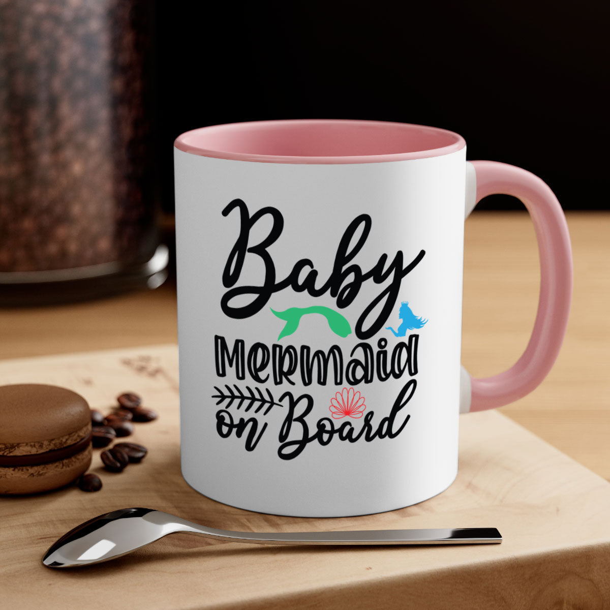 A colorful Baby Mermaid on Board mug with a glossy finish, featuring a mermaid design and a C-shaped handle, available in multiple colors.