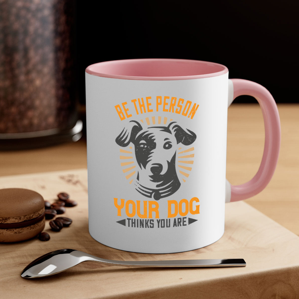 Ceramic coffee mug with a glossy finish featuring the phrase 'Be The Person Your Dog Thinks You Are' in a stylish design with a colored handle.