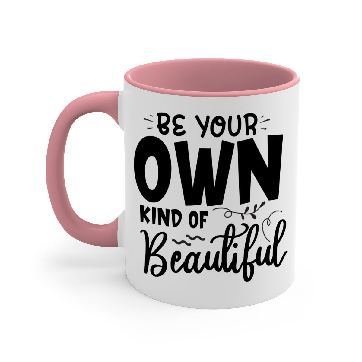 A stylish two-tone ceramic coffee mug with a glossy finish, featuring the phrase 'Be Your Own Kind of Beautiful' and a comfortable C-shaped handle.
