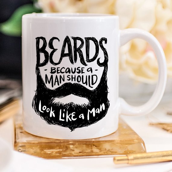 Funny coffee mug with the phrase 'Beards Because A Man Should Look Like A Man' printed on it, showcasing a humorous design.