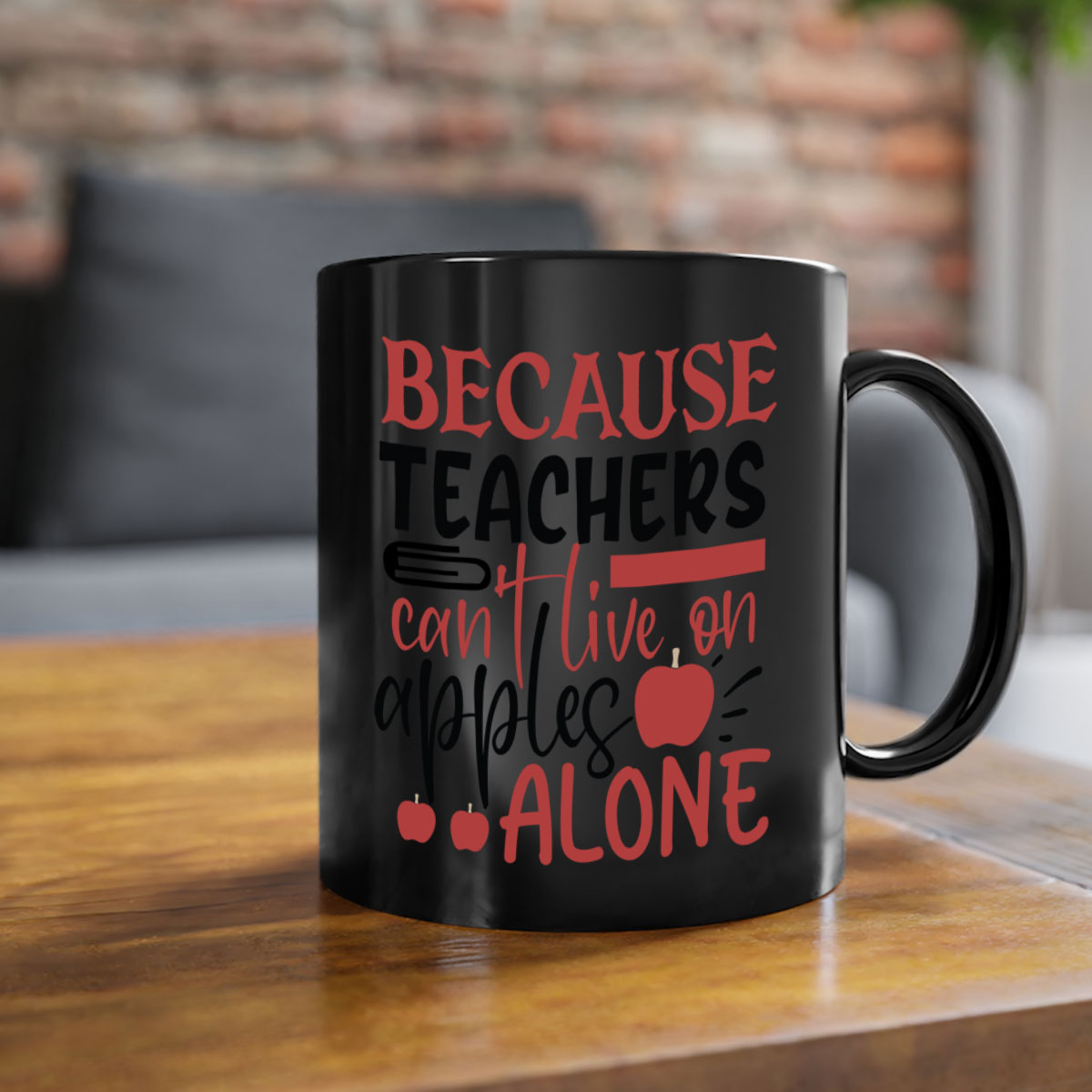 A two-tone ceramic mug with a colored handle and interior, featuring the phrase 'Because Teachers Can't Live on Apples Alone' in a stylish font.