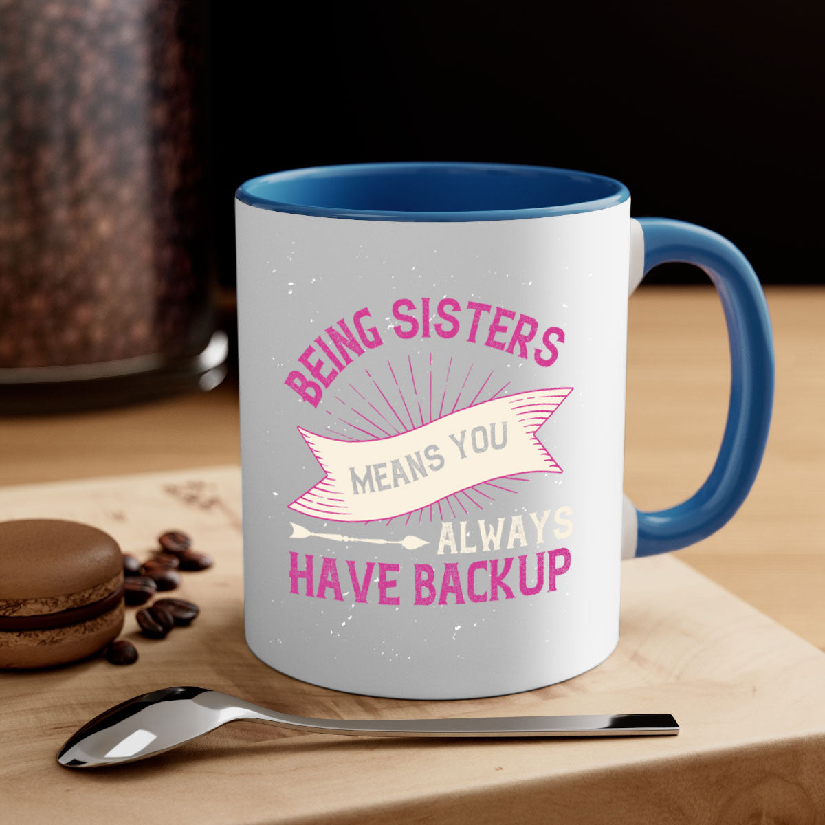 A stylish two-tone ceramic mug with a colored handle and interior, featuring the phrase 'Being Sisters Means You Always Have Backup'.