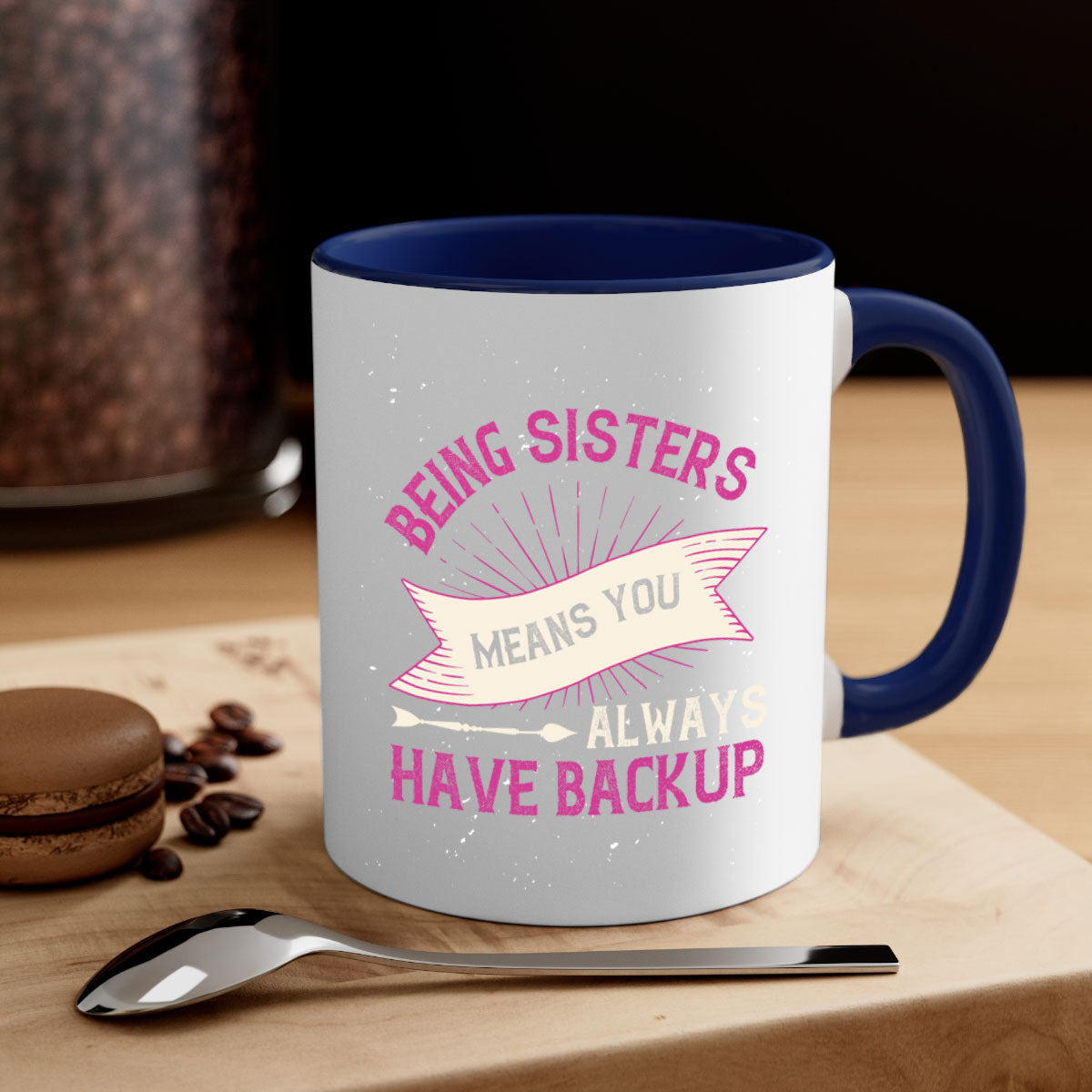 A stylish two-tone ceramic mug with a colored handle and interior, featuring the phrase 'Being Sisters Means You Always Have Backup'.