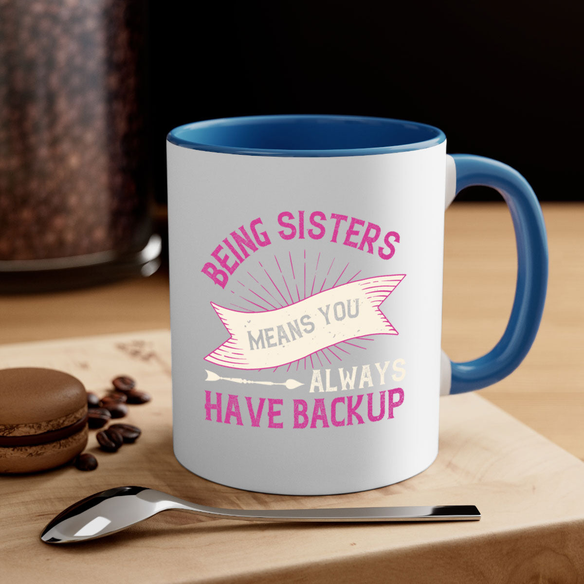 A stylish two-tone ceramic mug with a colored handle and interior, featuring the phrase 'Being Sisters Means You Always Have Backup'.