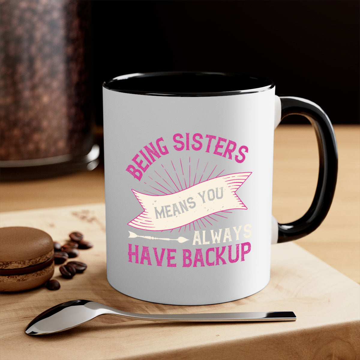 A stylish two-tone ceramic mug with a colored handle and interior, featuring the phrase 'Being Sisters Means You Always Have Backup'.