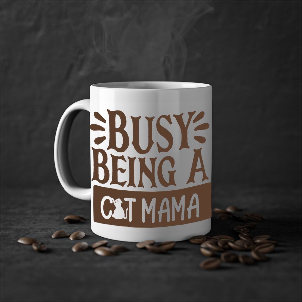 A two-tone ceramic mug with a colored handle and interior, featuring the phrase 'Busy Being A Cat Mama' in a stylish font.