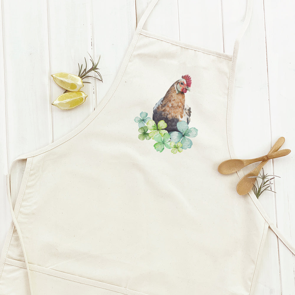 A stylish women's apron featuring a charming chicken and clover design, made from durable cotton canvas with adjustable neck and twill ties.