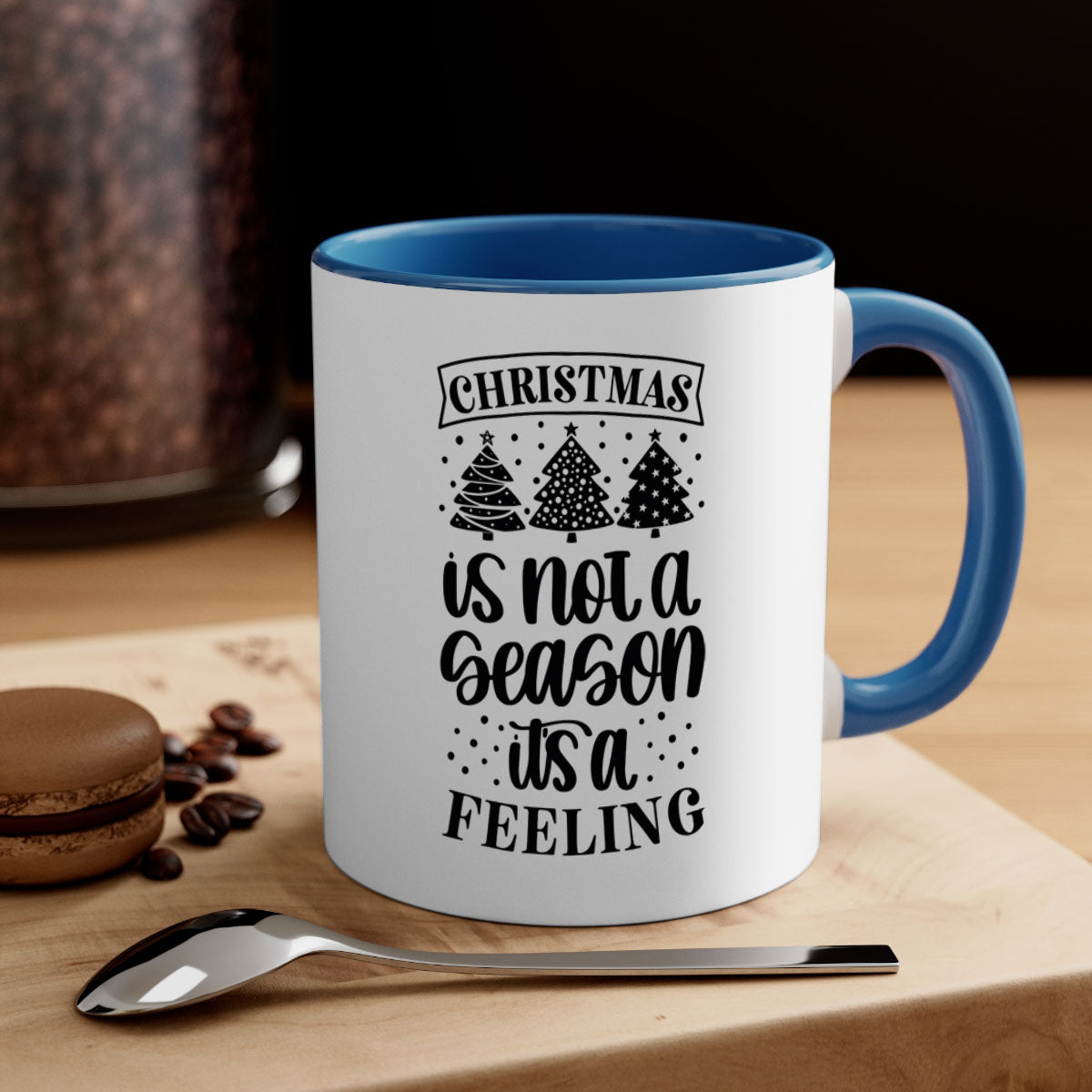 A two-tone ceramic mug with a glossy finish featuring the phrase 'Christmas is Not a Season, It's a Feeling', available in multiple colors.