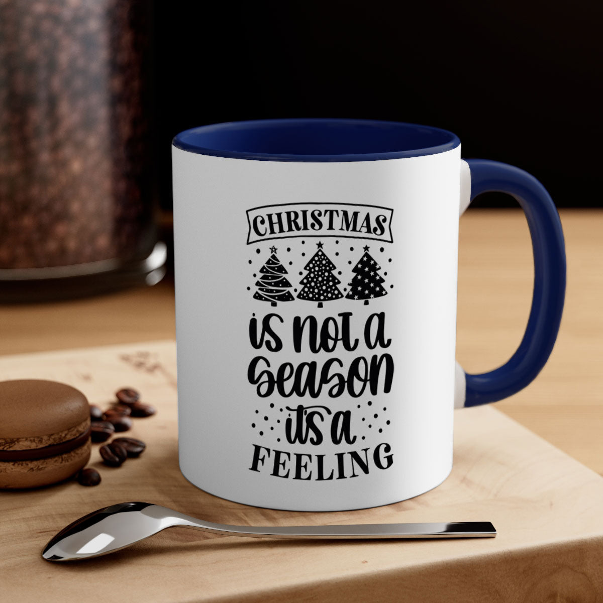 A two-tone ceramic mug with a glossy finish featuring the phrase 'Christmas is Not a Season, It's a Feeling', available in multiple colors.