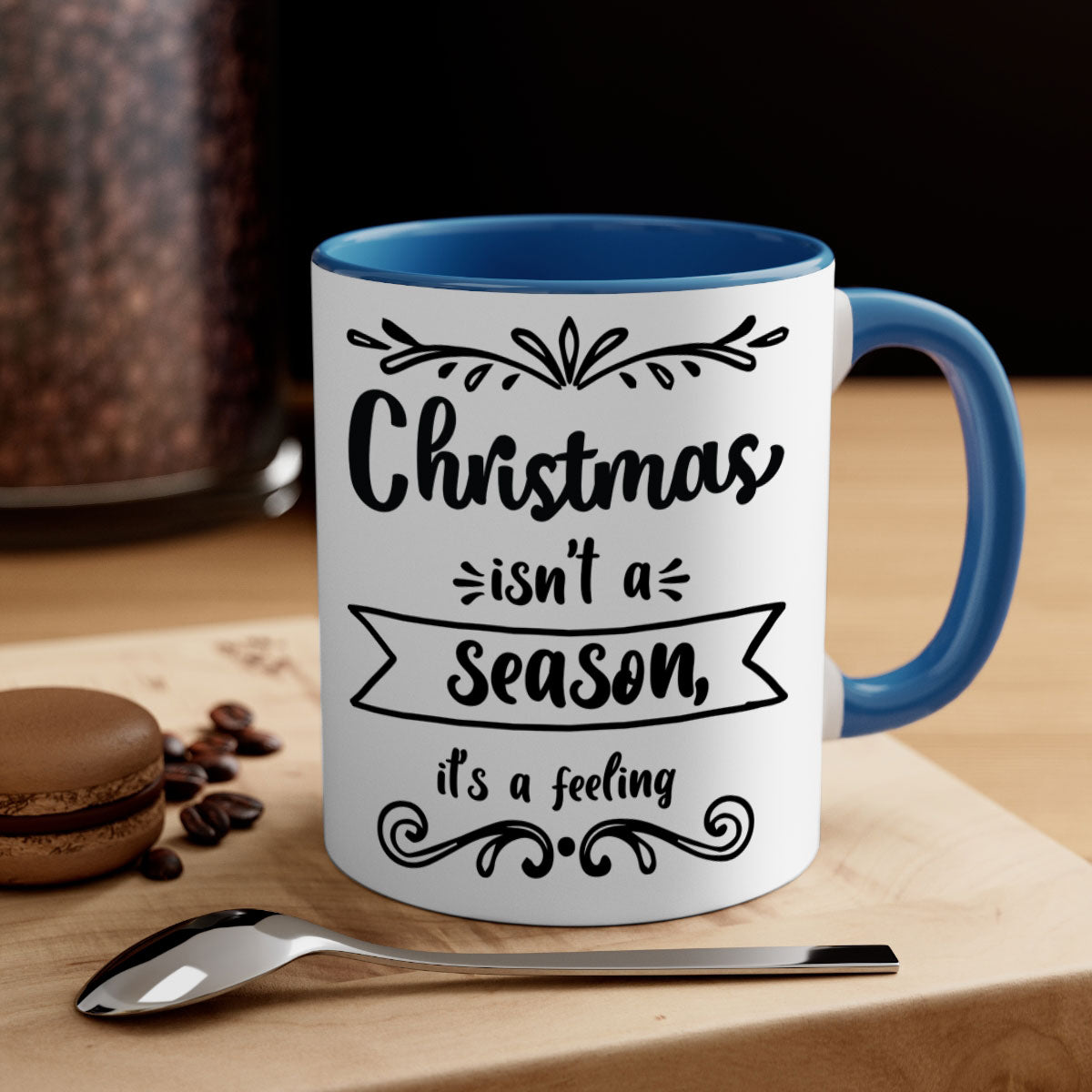 A festive two-tone Christmas mug with a colored handle and interior, featuring the phrase 'Christmas Isn't a Season, It's a Feeling'.