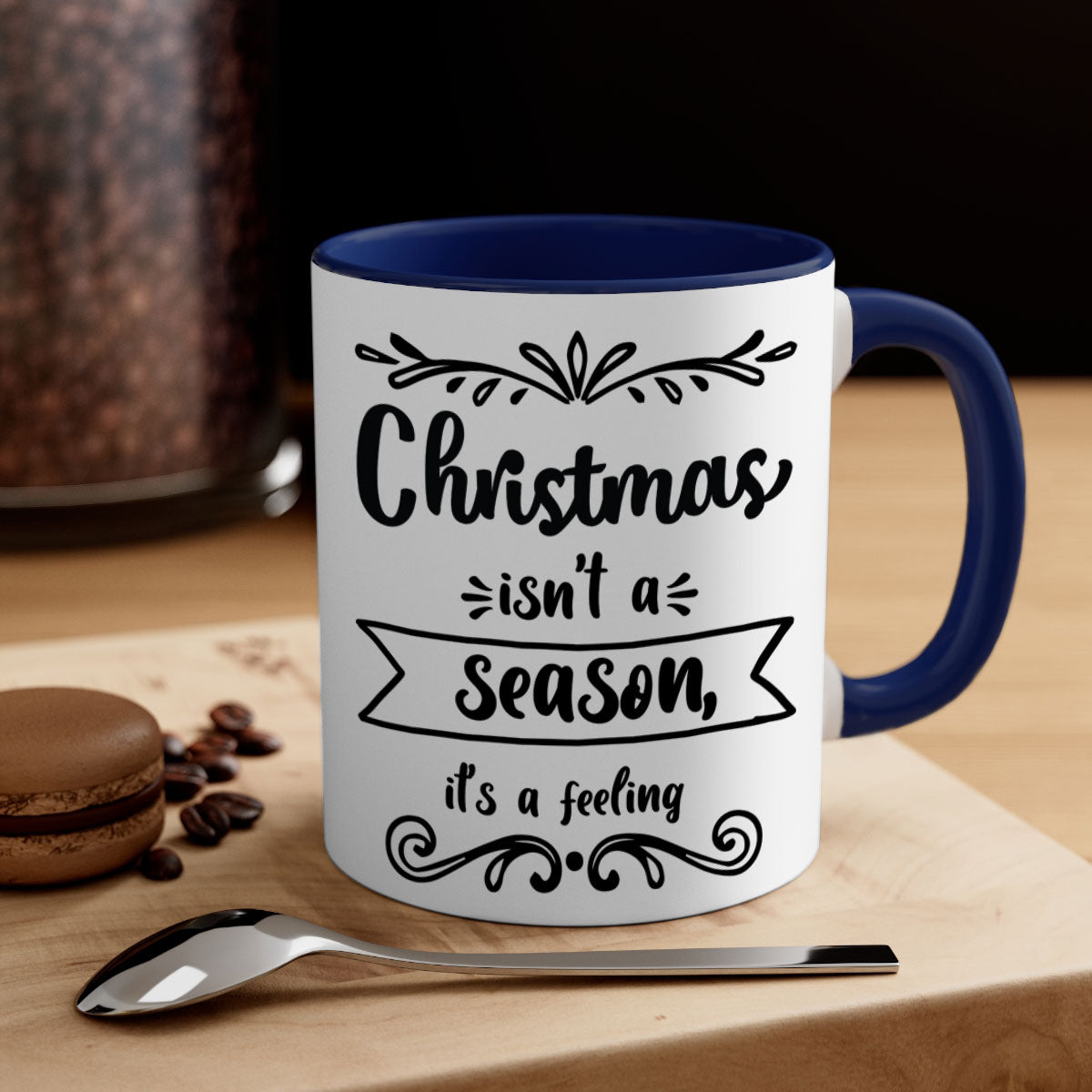 A festive two-tone Christmas mug with a colored handle and interior, featuring the phrase 'Christmas Isn't a Season, It's a Feeling'.