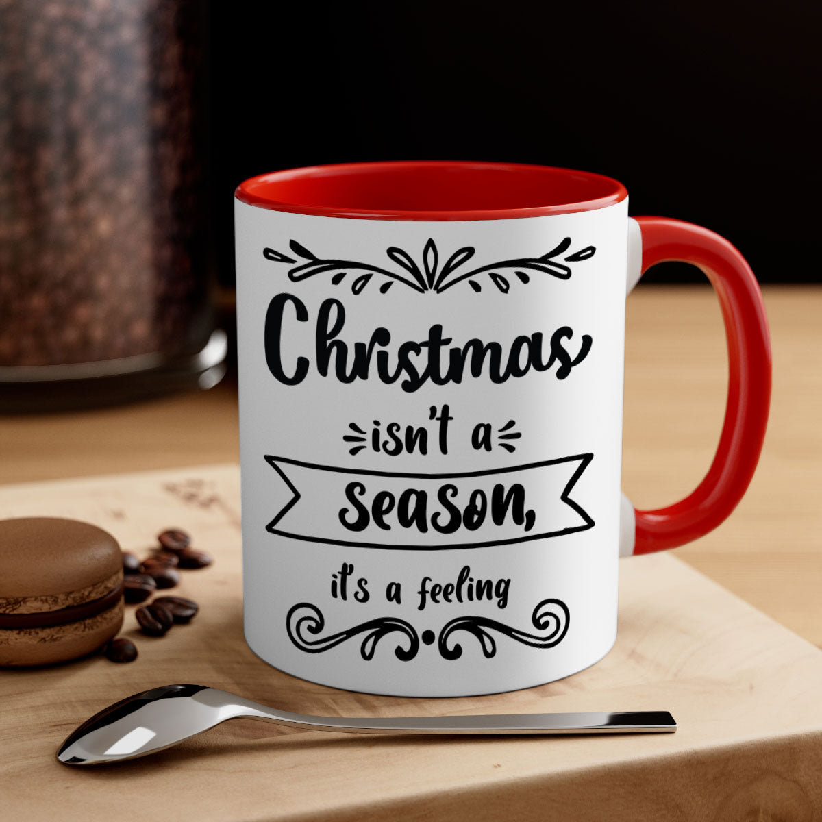 A festive two-tone Christmas mug with a colored handle and interior, featuring the phrase 'Christmas Isn't a Season, It's a Feeling'.
