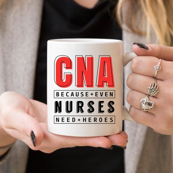 CNA - Because Even Nurses Need Heroes coffee mug featuring a humorous design, perfect for nurses and healthcare workers.
