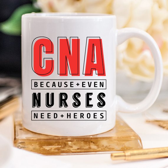 CNA - Because Even Nurses Need Heroes coffee mug featuring a humorous design, perfect for nurses and healthcare workers.