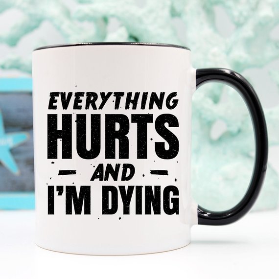 White ceramic coffee mug with humorous design 'Everything Hurts and I'm Dying' printed on both sides, available in 11 oz and 15 oz sizes.