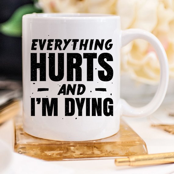 White ceramic coffee mug with humorous design 'Everything Hurts and I'm Dying' printed on both sides, available in 11 oz and 15 oz sizes.