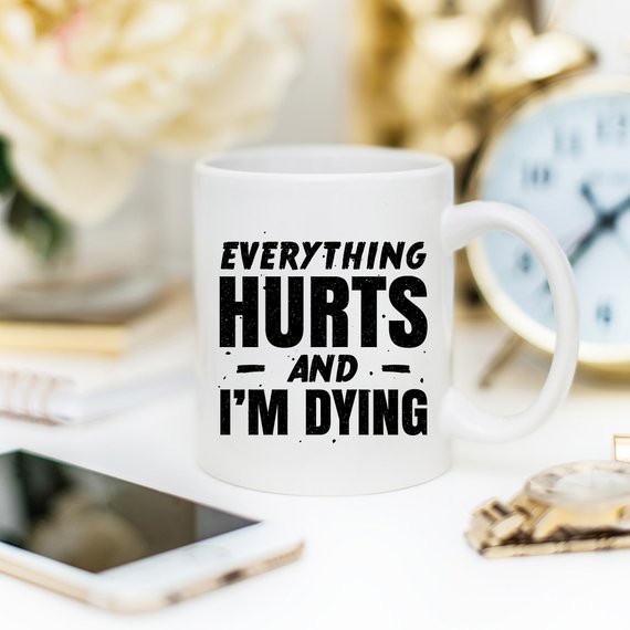 White ceramic coffee mug with humorous design 'Everything Hurts and I'm Dying' printed on both sides, available in 11 oz and 15 oz sizes.