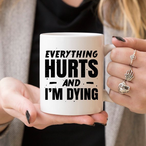 White ceramic coffee mug with humorous design 'Everything Hurts and I'm Dying' printed on both sides, available in 11 oz and 15 oz sizes.