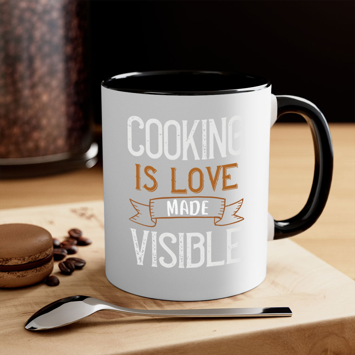 A two-tone ceramic coffee mug with a glossy finish, featuring the phrase 'Cooking is Love Made Visible' and a colorful handle.