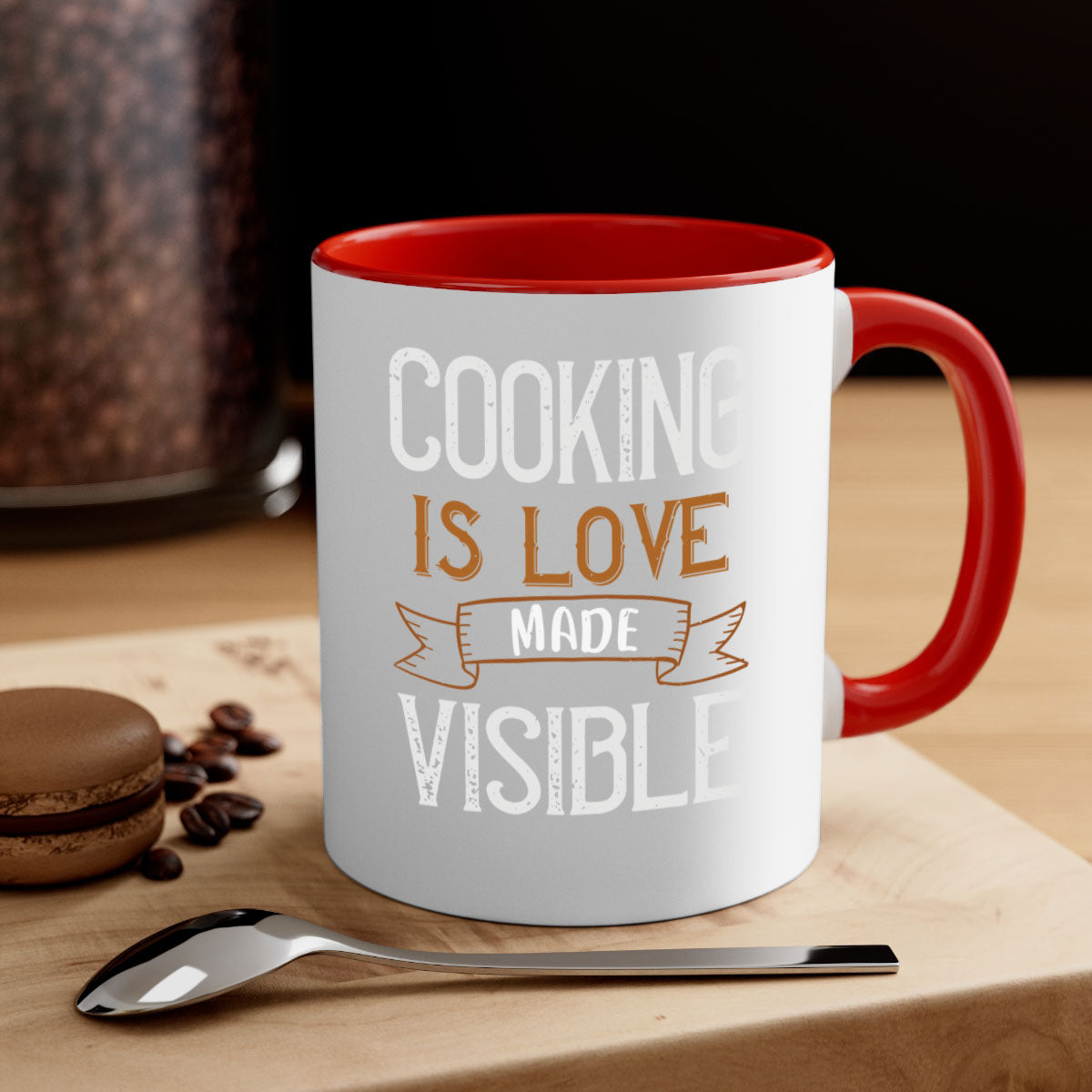A two-tone ceramic coffee mug with a glossy finish, featuring the phrase 'Cooking is Love Made Visible' and a colorful handle.