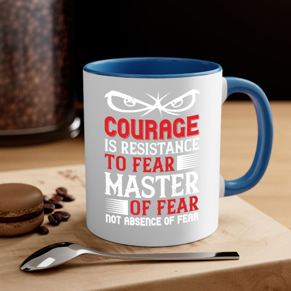 A stylish two-tone ceramic mug featuring the phrase 'Courage is Resistance to Fear' with a glossy finish and colored handle.