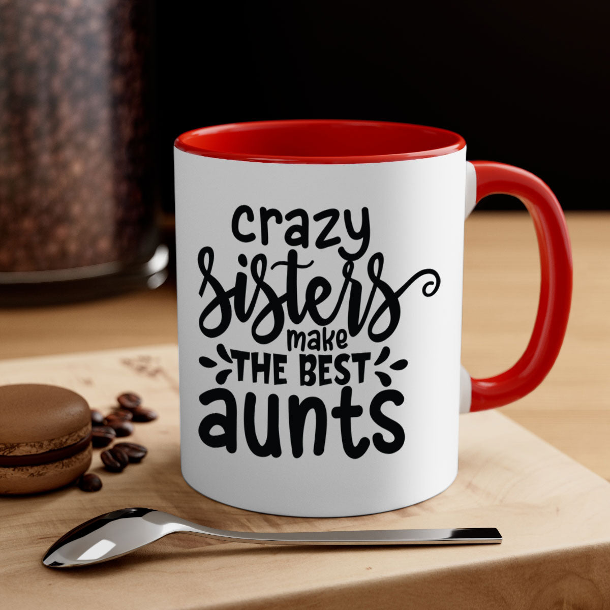 A two-tone ceramic coffee mug with the phrase 'Crazy Sisters Make the Best Aunts' printed on it, featuring a colored handle and glossy finish.