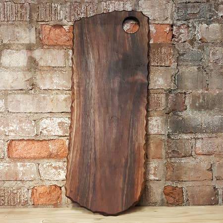 Large cutting board with chiseled edge and handle hole, perfect for kitchen use.