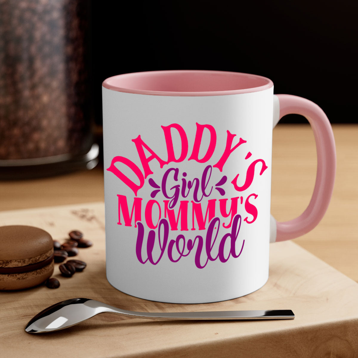 A two-tone ceramic coffee mug with a colored handle and interior, featuring the phrase 'Daddy's Girl Mommy's World' in a glossy finish.