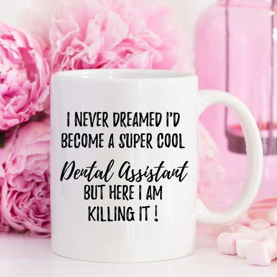 A white ceramic mug featuring a vibrant dental assistant design, showcasing both front and back prints.