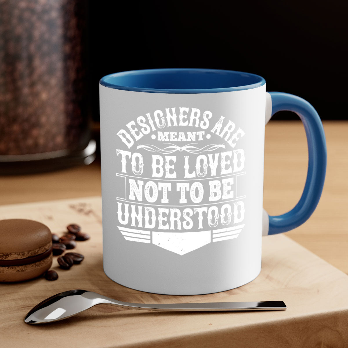 A stylish two-tone ceramic mug with a colored handle and interior, featuring the phrase 'Designers are meant to be loved not to be understood'.
