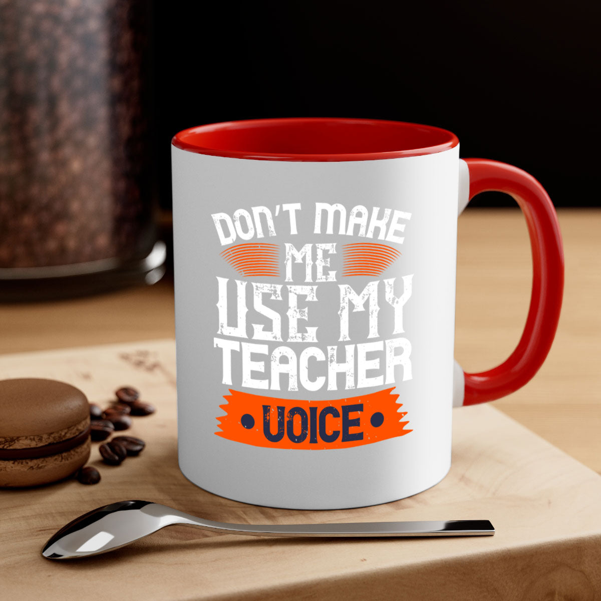 Ceramic coffee mug with a colorful handle and interior, featuring the quote 'Don’t make me use my teacher voice' in a stylish design.
