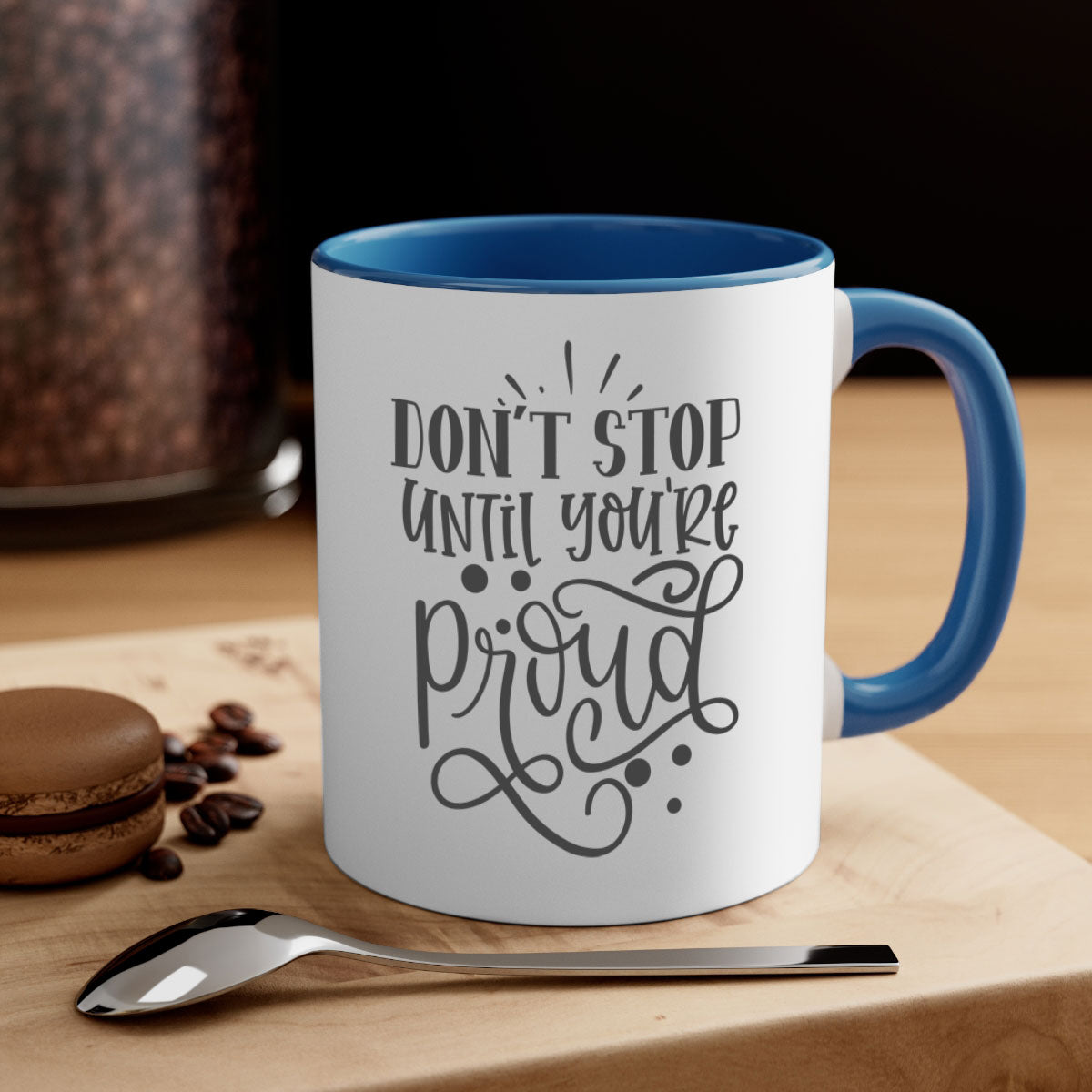 A stylish two-tone ceramic mug with a motivational quote 'Don't Stop Until You're Proud', featuring a colored handle and glossy finish.
