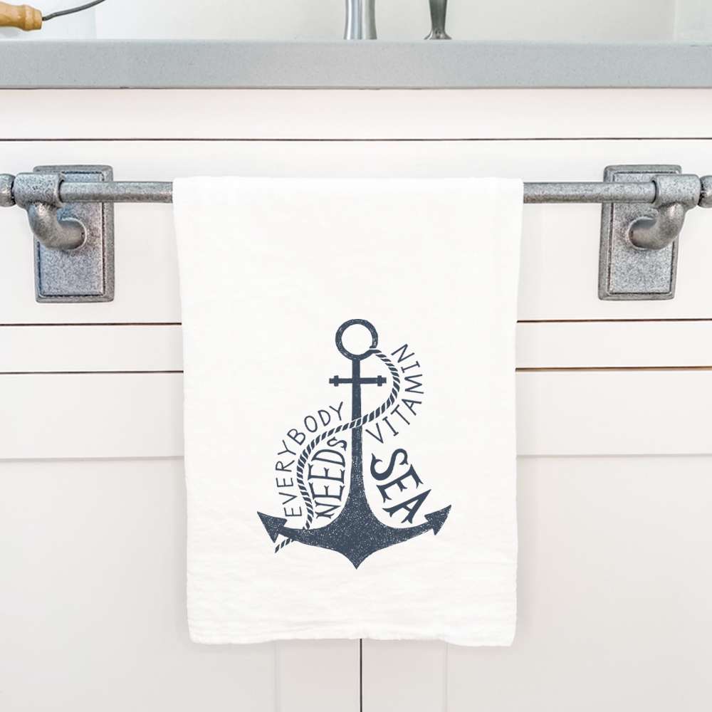 Cotton tea towel featuring 'Everyone Needs Vitamin Sea' design, vibrant colors, and hemmed edges, perfect for kitchen use.