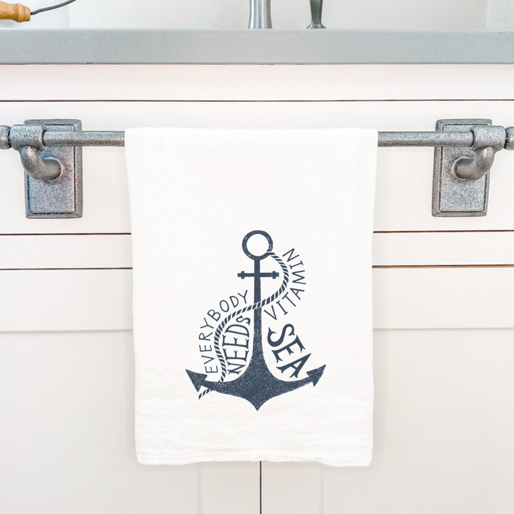 Cotton tea towel featuring 'Everyone Needs Vitamin Sea' design, vibrant colors, and hemmed edges, perfect for kitchen use.