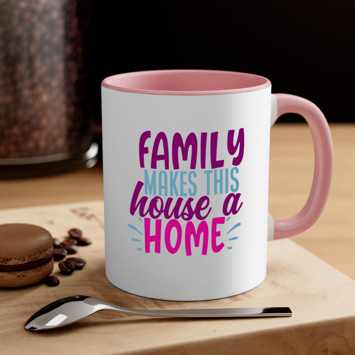 A two-tone ceramic coffee mug with the phrase 'Family Makes This House a Home' printed on it, featuring a colored handle and glossy finish.