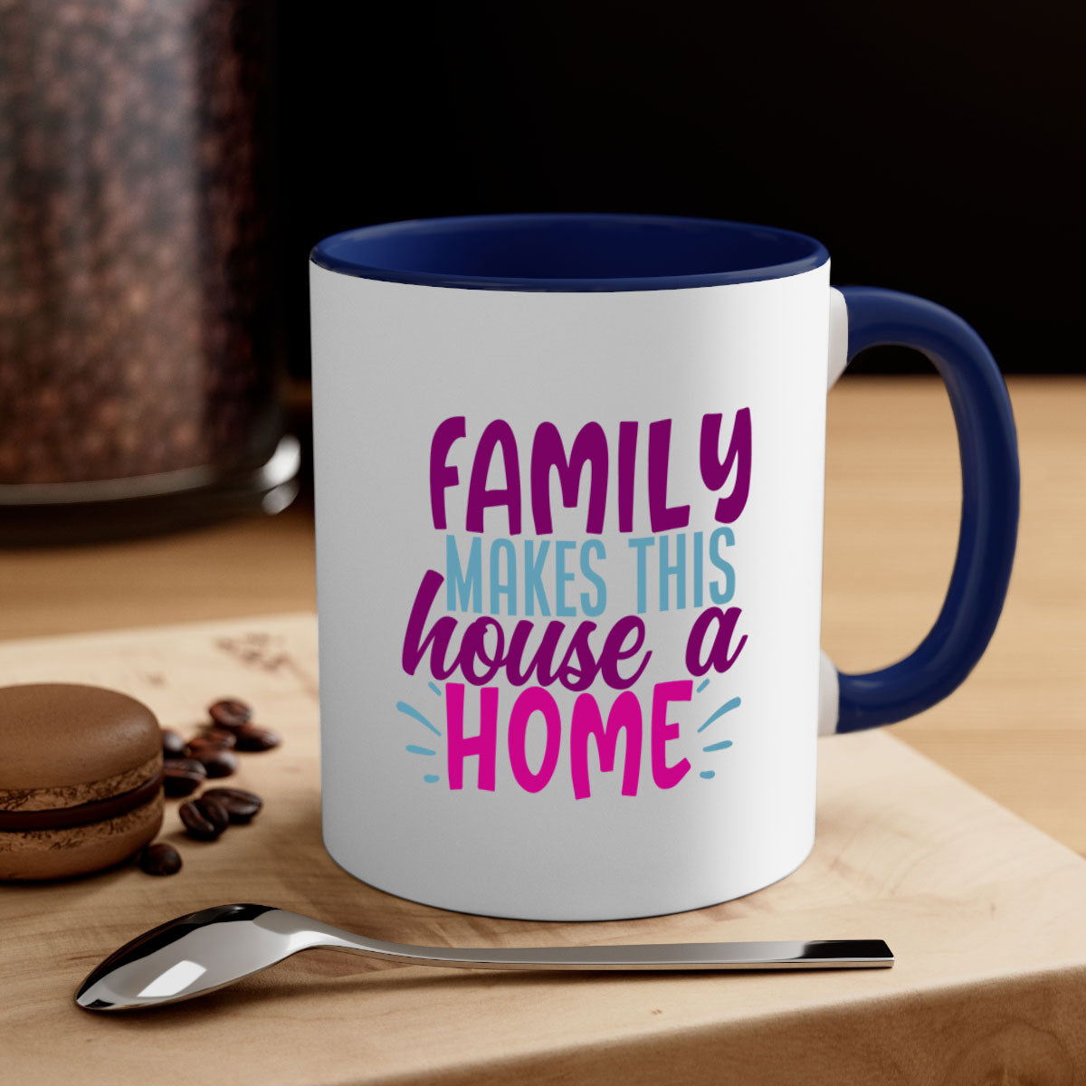 A two-tone ceramic coffee mug with the phrase 'Family Makes This House a Home' printed on it, featuring a colored handle and glossy finish.