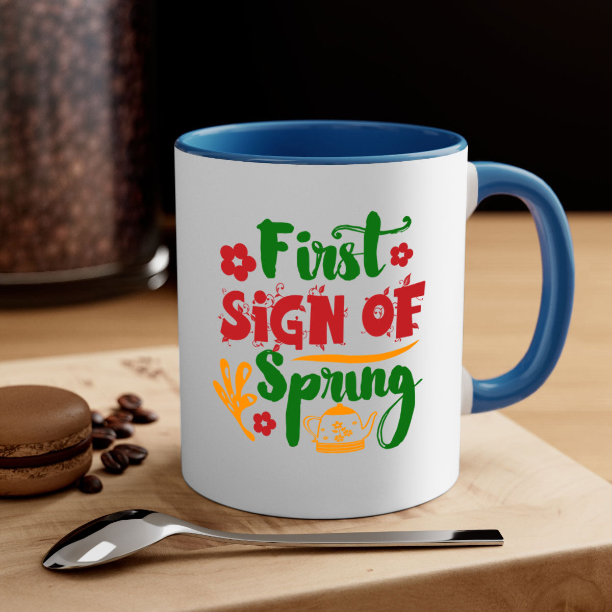 A two-tone ceramic coffee mug with a colored handle and interior, showcasing the First Sign of Spring design.