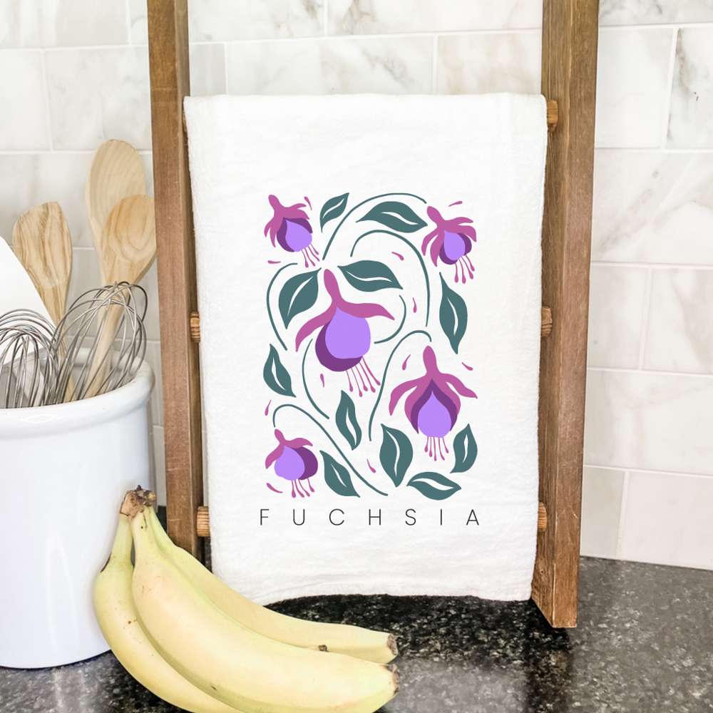 Fuchsia Cotton Tea Towel featuring a vibrant garden design, made from 100% absorbent cotton, displayed on a kitchen countertop.